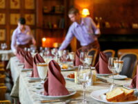 Waiters prepare a table for breakfast. Background. The foreground of napkins, dishes, toast, glasses. Calm atmosphere